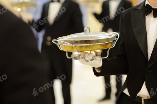Preview: Waiter Serving Dish With Candles In Restaurant