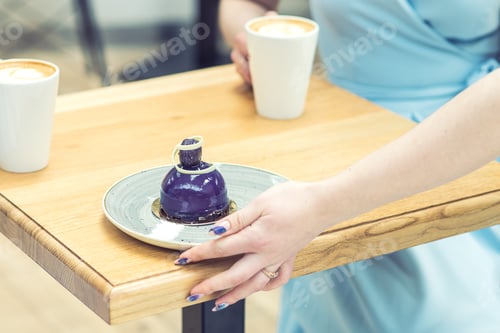 Preview: The Hand Of The Waiter Puts The Piece Of Cake On The Table At Cafe. Showing The Hand Of The Waiter.