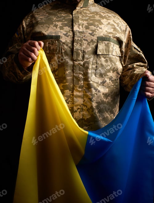 Preview: Ukrainian Soldier Holds In His Hand The Yellow-Blue Flag Of The State, Dark Background