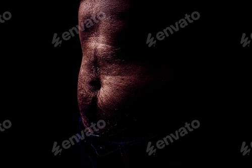 Preview: Close Up Of Perfect Male Body With A Belly Or Paunch Isolated On Black Background With Copy Space.