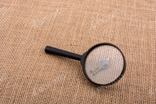 Preview: Tiny Figurine Of Man Miniature Model Under Magnifying Glass