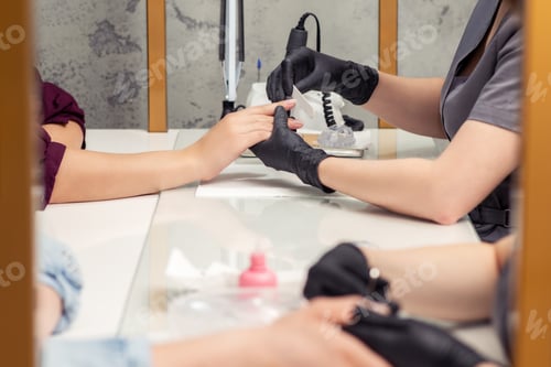 Preview: Female Hand Is Receiving A Manicure By Nail File In A Beauty Salon Side View.