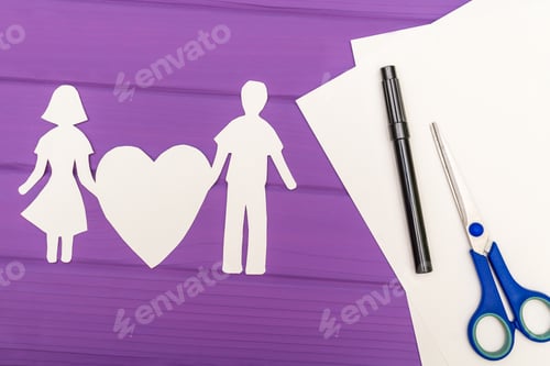 Preview: Paper Silhouette Of Man And Woman Holding Heart, Scissors And Marker Near On A White Sheet Of Paper