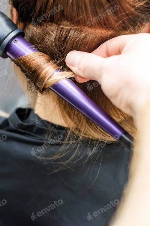 Preview: Closeup Of Hairdresser'S Hands With Curling Iron Are Making Hairdo At Hair Salon Background