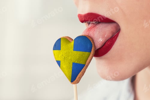 Preview: Closeup Photo Of The Woman Lips And Cookie Hearts With Flag Of Sweden