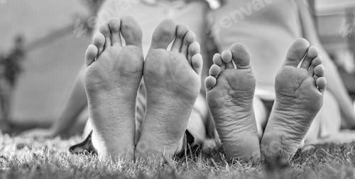 Preview: Romantic Young Couple Kissing In The Garden. Family Feet In Focus. Feet Of A Young Couple Lying On