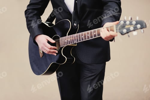 Preview: Man Plays Acoustic Guitar in Black Suit