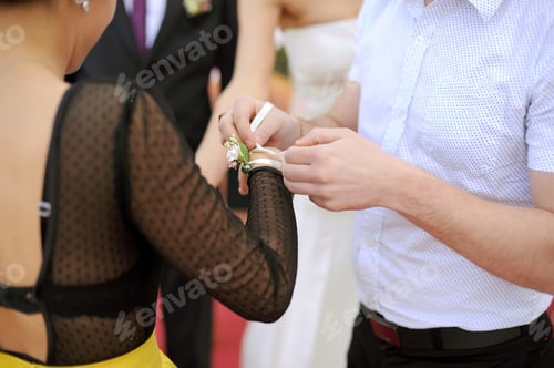 Preview: Hands Knotting Small Bouquet On Guest'S Hand