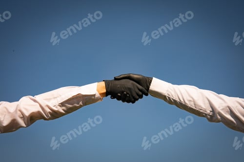 Preview: Handshake With Black Medical Gloves, Profile View On Blue Background. Covid-19 Coronavirus Ncov