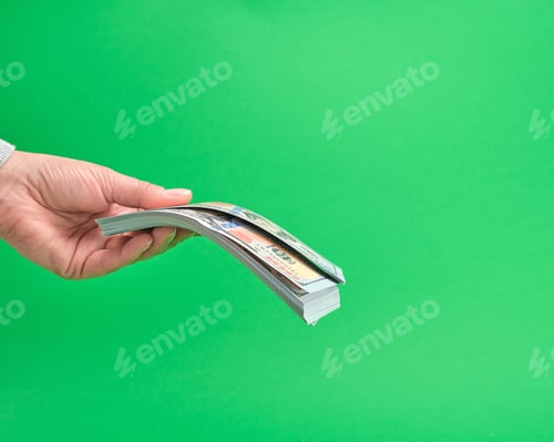Preview: Hand Holding Paper Money On A Green Background, Close Up