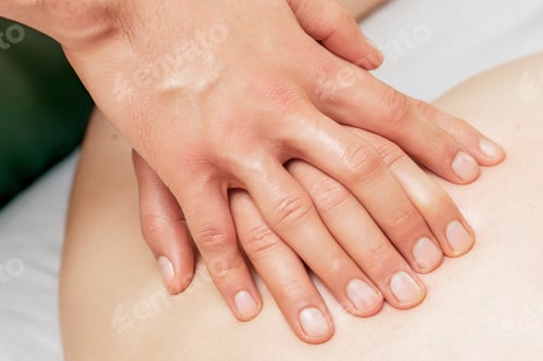 Preview: Woman Receiving Back Massage With Four Hands Of Two Male Therapists Close Up.