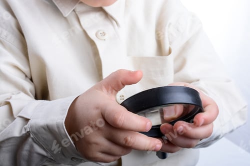 Preview: Baby Holding A Magnifying Glass In Hand On A White Background