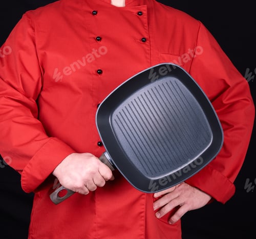 Preview: Cook In Red Uniform Holding An Empty Square Black Frying Pan, Black Background
