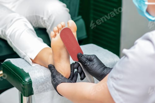 Preview: Pedicurist Cleans Foot With Special Grater For Scrubbing Heels.