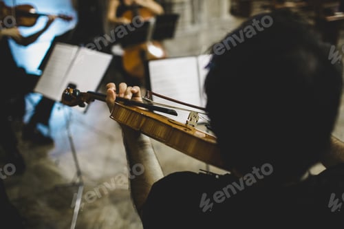 Preview: Violinists Holding The Mast Of Their Musical Instrument During An Interpretation.