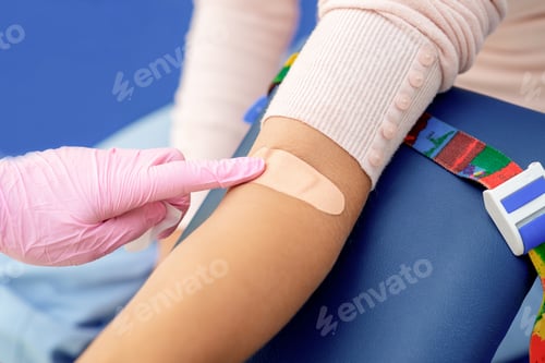 Preview: Doctor In Rubber Protective Gloves Glues An Adhesive Plaster On Arm After Blood Sampling.