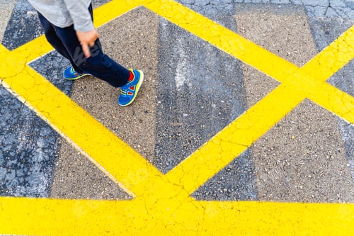 Preview: Child'S Legs On Yellow Lines On Asphalt.