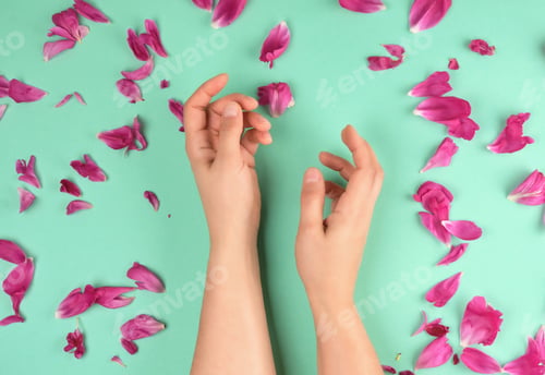 Preview: Two Hands Of A Young Girl With Smooth Skin And Red Peony Petals On A Green Background, Top View