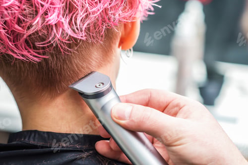 Preview: Close Up Hand Of Hairdresser Shaves Woman Pink Hair With Electric Shaver In Beauty Salon. Hands Are