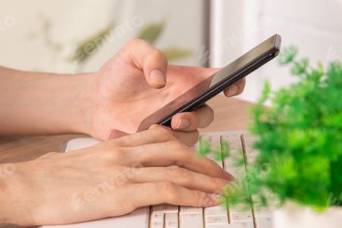 Preview: Close-Up Of Hands With Mobile Phone And Computer