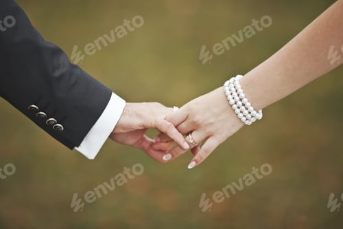 Preview: Man and Woman Holding Hands with Rings