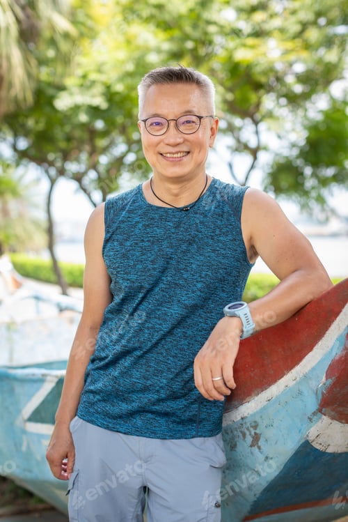Preview: Smiling Man Living With Hiv Leaning On A Parked Wooden Boat