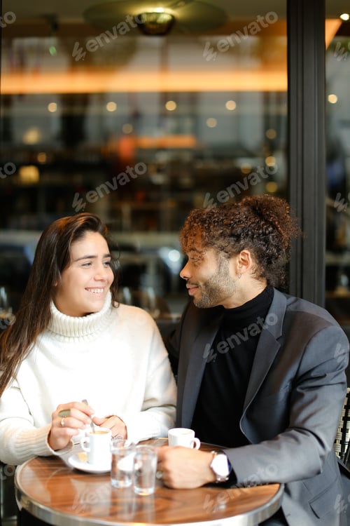 Preview: Afro American Man And Caucasian Smiling Lady Sitting At Street Cafe And Talking. Concept Of