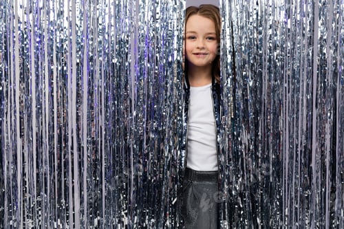 Preview: European Beautiful Teenage Girl In A Stylish Outfit On A Holiday Peeks Out From Behind A Tinsel