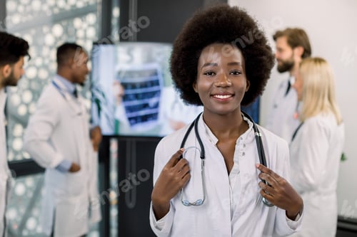 Preview: Smiling Pretty African-American Nurse Or Doctor, Posing To Camera In Clinic. Multiracial Medical