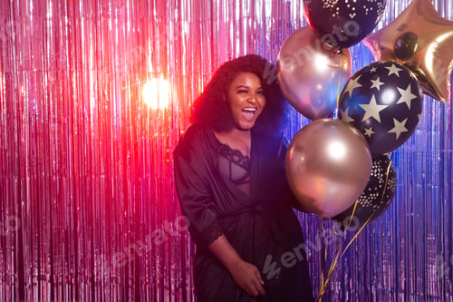 Preview: Portrait Of A Beautiful African American Woman Against Twinkling Background. Birthday Party