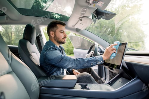 Preview: Cleaning Time, Car Detailing Concept. Portrait Of Young Handsome Caucasian Man With Beard Sitting