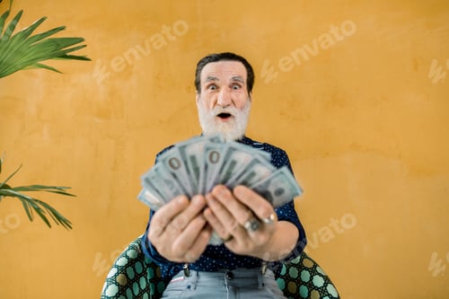 Preview: Funny Photo Of Cheerful Excited Gray-Bearded Man Holding A Lot Of Paper Money In Hands, And Posing
