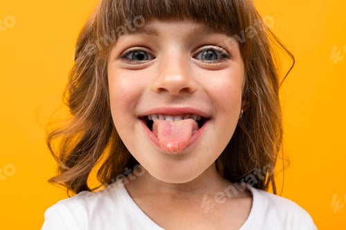 Preview: Closeup Portrait Of A Girl Showing Tongue On A Yellow Background