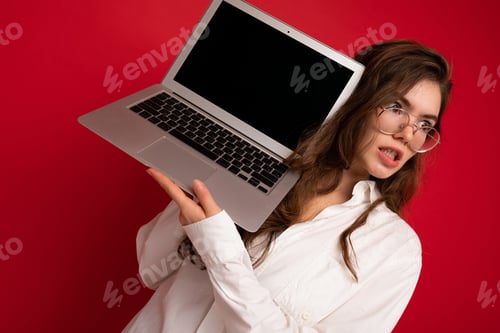 Preview: Beautiful Brunette Curly Young Woman Holding Computer Laptop Wearing Glasses White Shirt Looking To