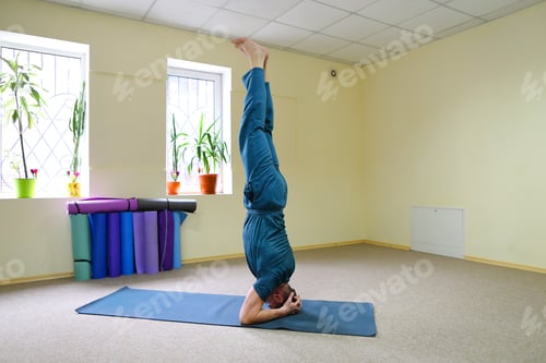 Preview: Young Man Sports Athlete Doing Yoga Sitting On Floor In Room. Building Is Spacious And Light, On