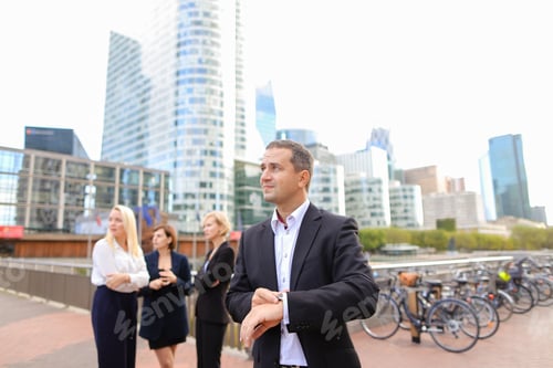 Visualização: Empresário satisfeito olhando um relógio em La Defense Paris,. Conceito de gerenciamento de tempo e negócios
.