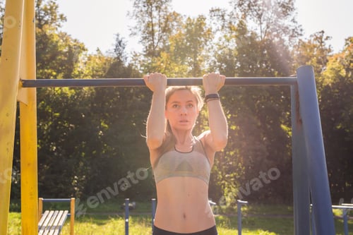Preview: Young Beautiful Girl Doing Chin-Ups On The Outdoor Sports Ground