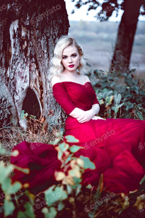 Preview: Fashion Gorgeous Young Blonde Woman In Beautiful Red Dress In A Fairy-Tale Forest. Magic Atmosphere
