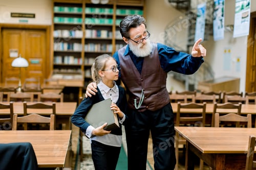 Preview: Cute Interested Teen Schoolgirl Holding A Big Book And Listening Her Intelligent Senior Bearded