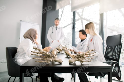 Preview: Human Skeleton Model On The Table In Classroom. Group Of International Medical Students With Male