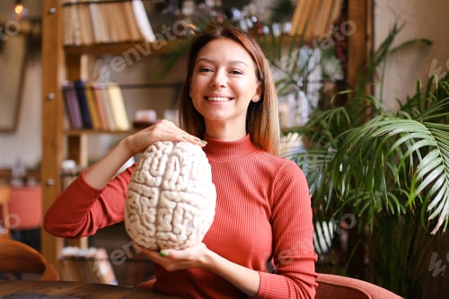 Preview: Female Smiling Caucasian Psychologist Holding Human Brain Model At Cabinet. Concept Of Anatomy And