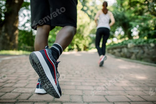 Preview: Close Up Back View Photo Of Legs Of African Man In Sport Sneakers Jogging In The City Park On A