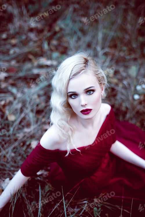 Preview: Fashion Gorgeous Young Blonde Woman In Beautiful Red Dress In A Fairy-Tale Forest. Magic Atmosphere