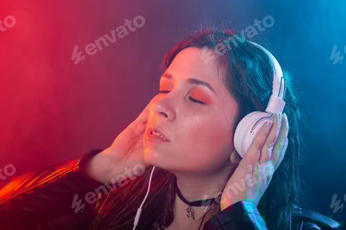 Visualização: Jovem mulher com dreadlocks aprecia a música em seus fones de ouvido