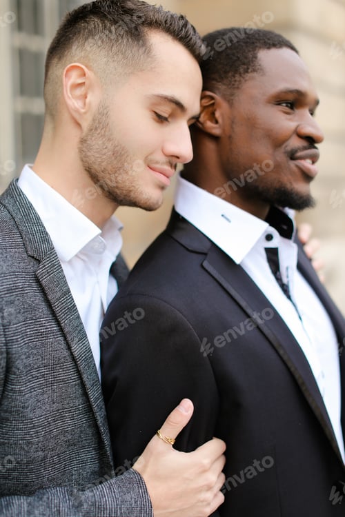 Preview: Caucasian Man Hugging Afro American Boy, Wearing Suit. Concept Of Relationship And Same Sex Couple.