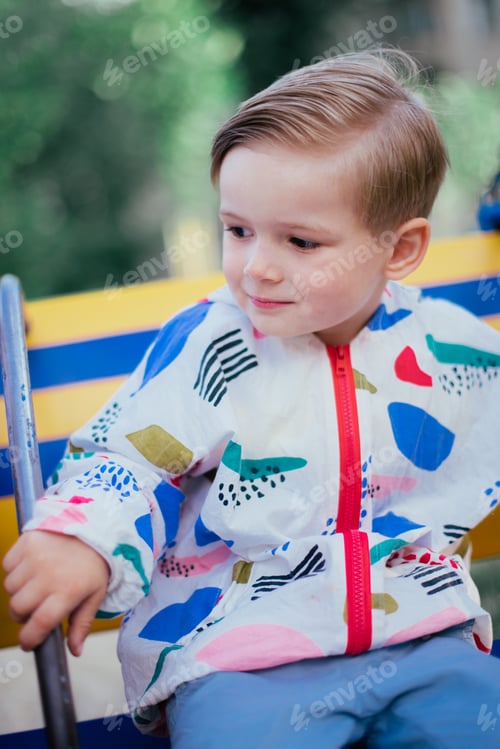 Preview: A Young Cute Happy 4 Years Old Boy Posing And Playing Outside, Wearing Colorfull Jacket