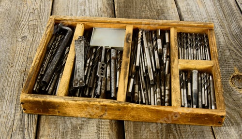 Preview: Working Tools. A Box With Drills On A Wooden Background.
