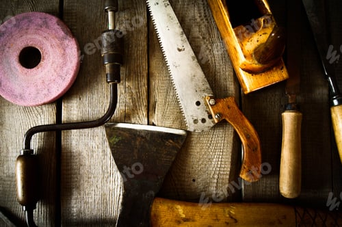 Preview: The Old Working Tool. Many Old Working Tools ( Axe, Saw And Others) On A Wooden Background.