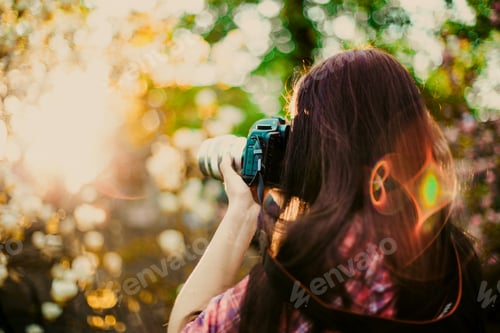 Preview: Young Photographer With Long Hair Takes Picture With Camera Outside With Summer Sun Light