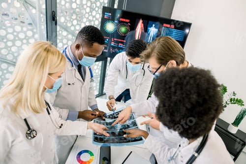 Preview: Top Angle View Of Multiethnical Team Of Doctors In Medical Masks, Examining Ct Scan Together